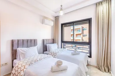 a bedroom with two beds and a window at Modern Gueliz, Hivernage City Centre 2 Bedroom Apartment in Marrakech