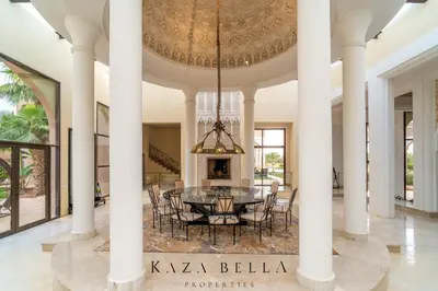 a dining room with a table and chairs and a chandelier at KAZA BELLA - Palais Les Orchidées in Marrakech