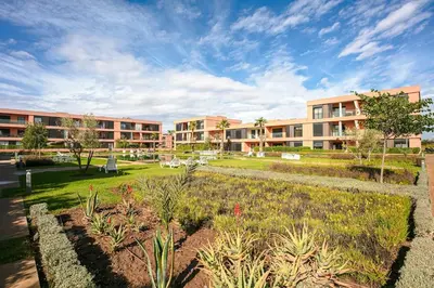 an apartment complex with a garden in front of a building at The Velvet Retreat - Marrakech in Marrakech