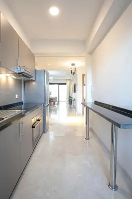 a kitchen with stainless steel appliances and a long hallway at The Velvet Retreat - Marrakech in Marrakech