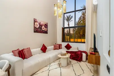 a white living room with a white couch and red pillows at Grand duplex 4 ch - Piscine - Marrakech in Marrakech