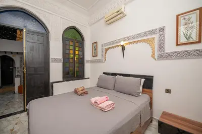 a bedroom with a bed with two pink towels on it at Riad Pearl Marrakech 4 Rooms Jacuzzi Terrace shared Pool in Marrakech