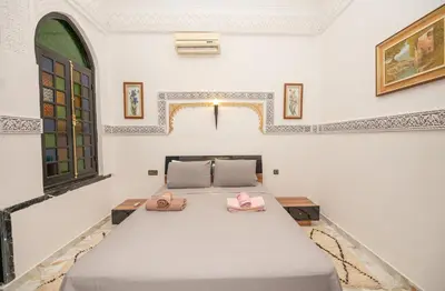a bedroom with a bed with two pink slippers at Riad Pearl Marrakech 4 Rooms Jacuzzi Terrace shared Pool in Marrakech