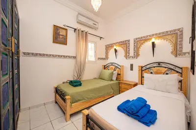 a bedroom with two twin beds and a window at Riad Pearl Marrakech 4 Rooms Jacuzzi Terrace shared Pool in Marrakech