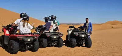 a group of people riding atvs in the desert at Menara Airport Transfers in Marrakech