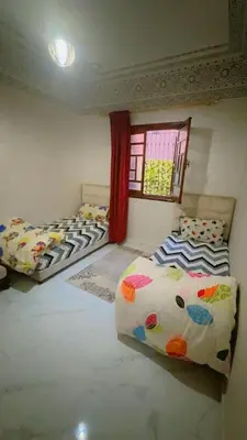 three beds in a room with a window at Chic & Cozy Apartment in Marrakech