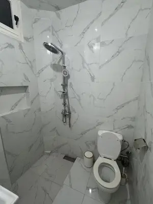 a white bathroom with a toilet and a shower at Chic & Cozy Apartment in Marrakech