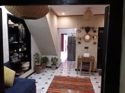 a living room with a table and a refrigerator at Dar tranquille in Marrakech