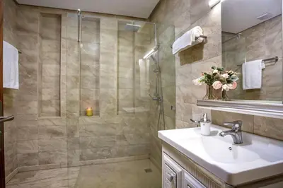 a bathroom with a shower and a sink and a mirror at Villa de luxe et plaisir in Marrakech