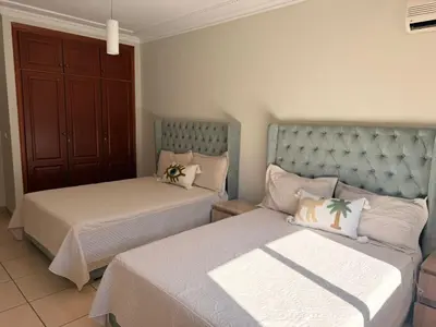 a bedroom with two beds and a cabinet at Tay Home in Marrakech