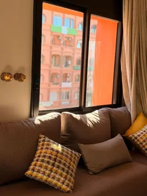 a couch with pillows sitting in front of a window at Tay Home in Marrakech