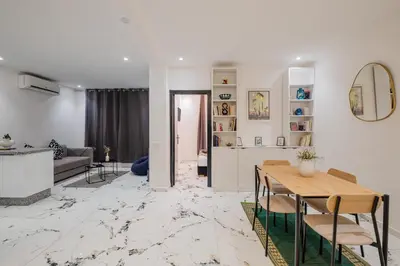 a living room with a table and a couch at Modern & Cozy Apartment 2 min Carré Eden Guéliz in Marrakech