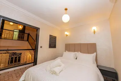 a bedroom with a white bed and a staircase at Riad Marrakech 4-bedroom Riad in the heart of Marrakesh with Pool in Marrakech