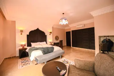 a bedroom with a bed and a couch and a table at Royal Moroccan House in Marrakech