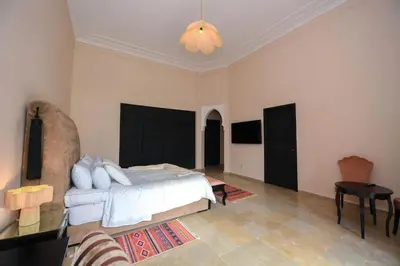 a bedroom with a bed and a chandelier at Royal Moroccan House in Marrakech