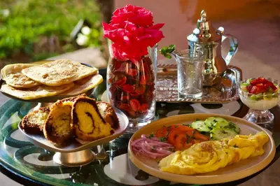 a table with plates of food on a glass table at Royal Moroccan House in Marrakech
