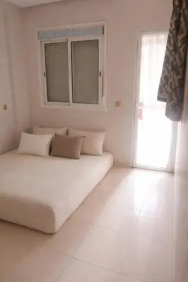 a white room with a bed and a window at appartement pour famille ou femme in Marrakech