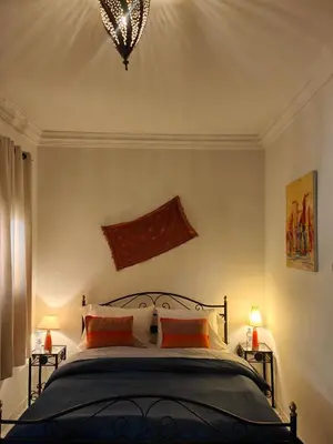 a bedroom with a large bed with two lamps at Riad Palm Oasis Marrakech in Marrakech