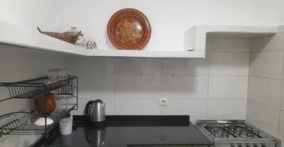a kitchen with a stove and a plate on a shelf at Pied-à-terre Calme & Climatisé à 5 min du Centre in Marrakech