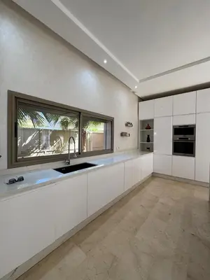 a kitchen with white cabinets and a large window at Villa 60 Saphir in Marrakech
