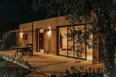 a house with glass doors and a table on a patio at Villa Yemna - Villa signature Paddle Marrakech in Segraga