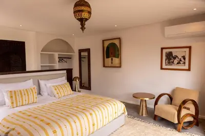a bedroom with a king sized bed and a chair at Villa Yemna - Villa signature Paddle Marrakech in Segraga