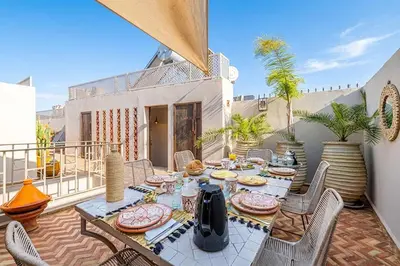 a patio with a table and chairs on a balcony at Riad Kenous - Exclusive&New -6 pax- Pool & Breakfast in Marrakech
