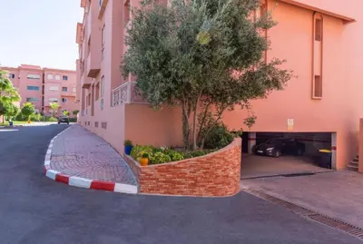a tree in a brick wall next to a building at Marrakech Cozy Family Home piscine et wifi in Marrakech