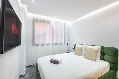 a white bedroom with a bed with a tv on it at Modern apartment, design and cozy relaxing stay in Marrakech