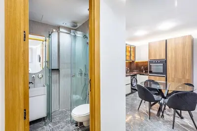 a bathroom with a glass shower and a table and chairs at Modern apartment, design and cozy relaxing stay in Marrakech