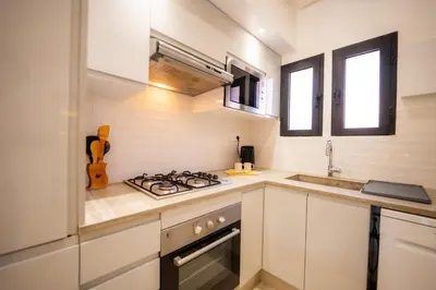 a kitchen with a stove top oven next to a sink at 1 Bedroom Apartment with Private Garden, Terrace and Pool in Marrakech