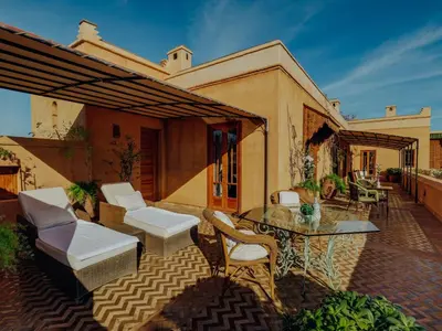 an outdoor patio with a table and chairs at Casa Memoria in Marrakech