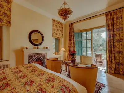a bedroom with a bed and a desk and a fireplace at Casa Memoria in Marrakech