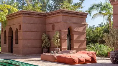 a brown building with a bed in front of it at Villa Rehame in Oulad Jellal
