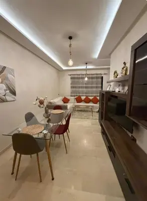 a living room with a table and chairs and a couch at Le lux de gueliz in Marrakech