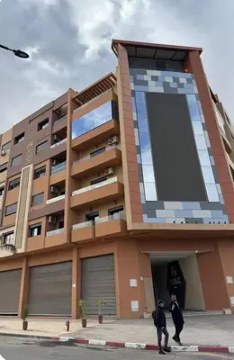 two people walking in front of a building at Le lux de gueliz in Marrakech
