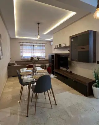 a living room with a table and a large television at Le lux de gueliz in Marrakech