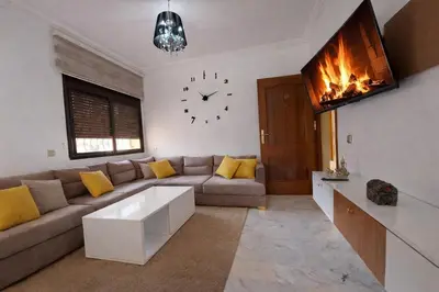 a living room with a couch and a clock on the wall at Elegant cocoon in Guéliz with 2 bedrooms in Marrakech
