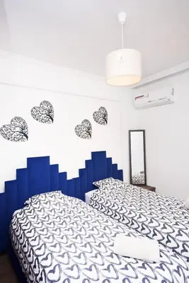 a bedroom with a bed with a blue headboard at Marrakech Station Apartment in Marrakech