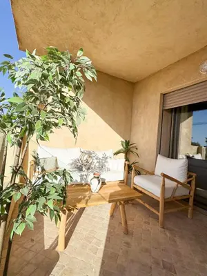 a patio with a bench and a table and a window at Noraya Home - Secure residence with pool in Marrakech