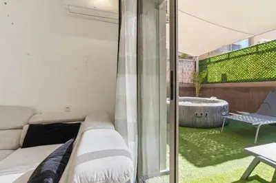 a living room with a couch and a tub at T2 - Terrasse et Jacuzzi - Coeur de Guéliz in Marrakech