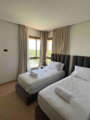 a bedroom with two beds and a window at Super 3-bedroom living room with view of Prestigia Golf Pools in Marrakech