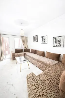 a white living room with couches and a table at Residence Nadia in Marrakech