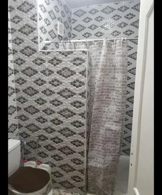 a bathroom with a shower curtain and a toilet at Boston in Marrakech