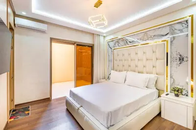 a bedroom with a large bed with a large headboard at Luxury 2-bedroom apartment in Marrakech