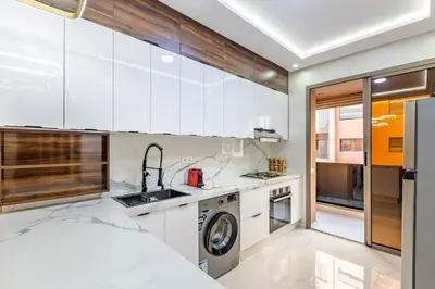 a kitchen with white cabinets and a washer and dryer at Luxury 2-bedroom apartment in Marrakech