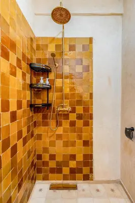 a bathroom with a shower with a tiled wall at Beautiful Moroccan 2BR Close to City Center in Marrakech
