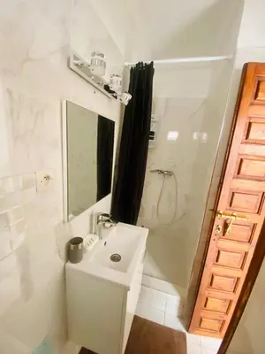 a white bathroom with a sink and a shower at Havre de Paix in Marrakech