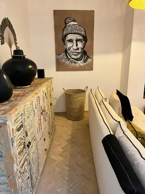 a living room with a couch and a painting on the wall at Riad Dar Khadra Heritage - Piscine chauffée et Rooftop au cœur de la médina in Marrakech