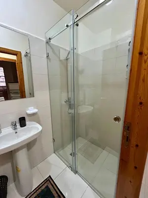 a bathroom with a glass shower and a sink at Appartement 2 chambres à 10mn du centre ville in Marrakech